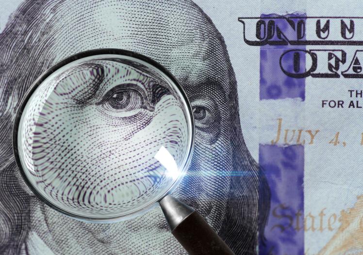 100 US Dollar under magnifying glass