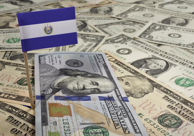 Flag of El Salvador sticking in various american banknotes