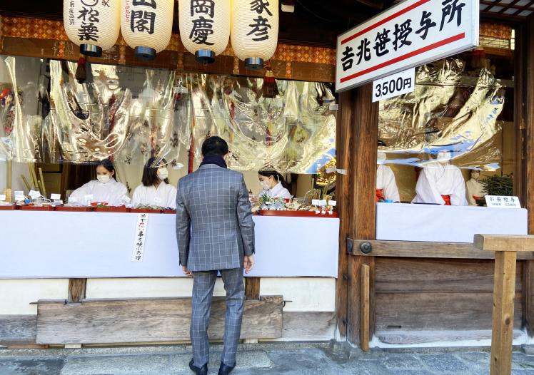 Businessman buying a Fuku-Zasa - a type of bamboo 