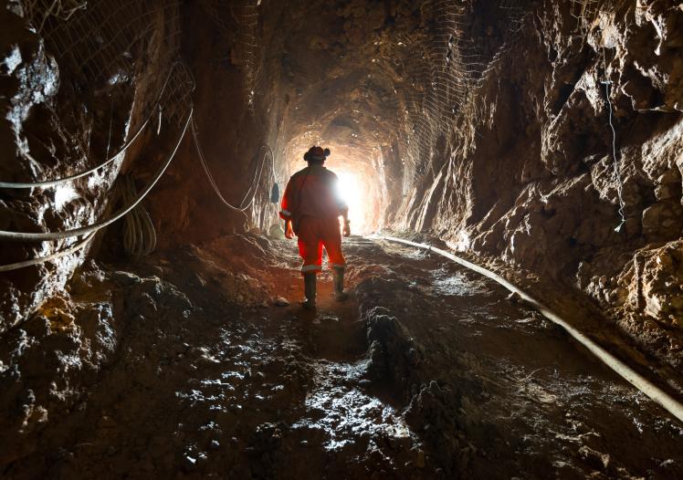 Miner inside the access tunnel of an underground gold and copper mine