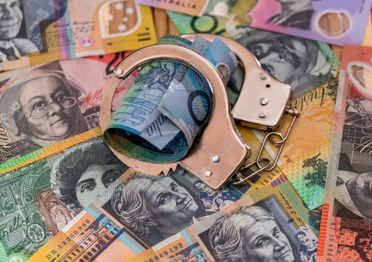 Steel handcuffs on australian dollars