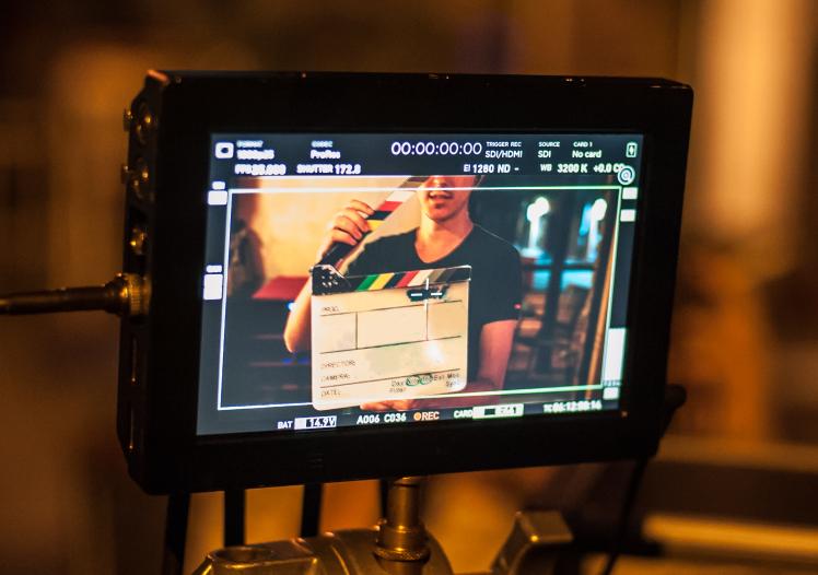 Man holding a clapper board in front of the camera 
