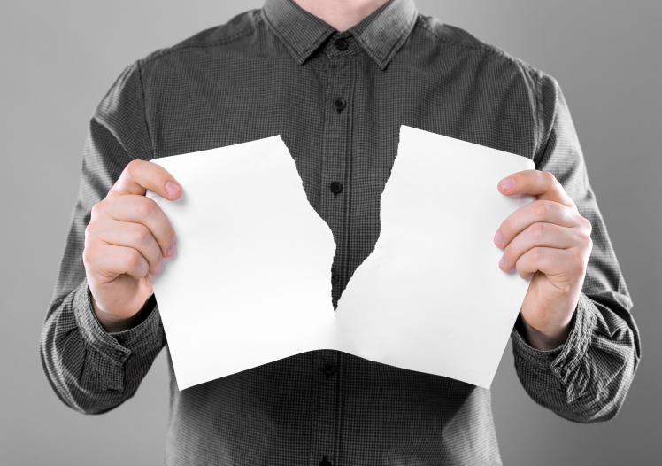 Man ripping sheet of paper 