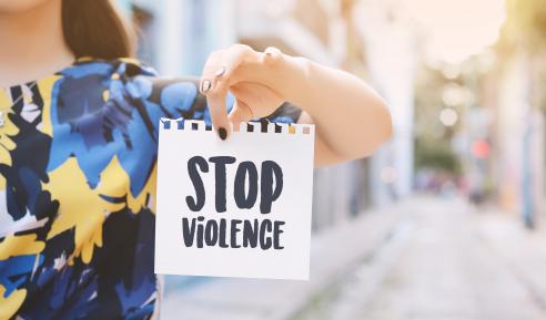 Young woman showing a notepad with the text "stop violence"