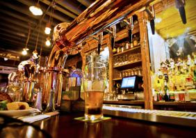 Glass of beer and beer taps in a bar