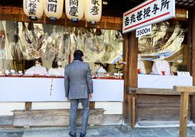 Businessman buying a Fuku-Zasa - a type of bamboo 