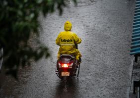 Blinkit gig driver on moped in the rain