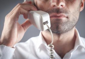 man talking on office telephone