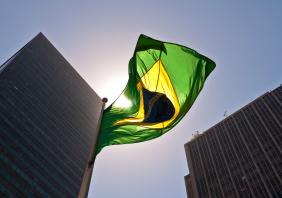 A Brazilian flag in front of skyscrapers