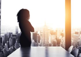 Silhouetted shot of a young businesswoman looking at a cityscape