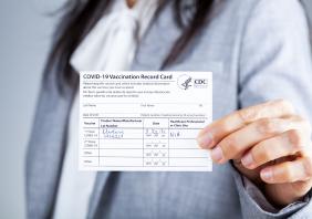Woman showing Vaccination record card