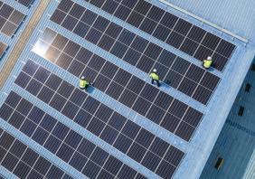 Engineers checking on solar panel on the factory rooftop 