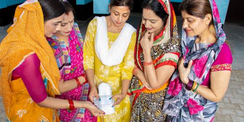 Young indian woman educating other women about sanitary pads