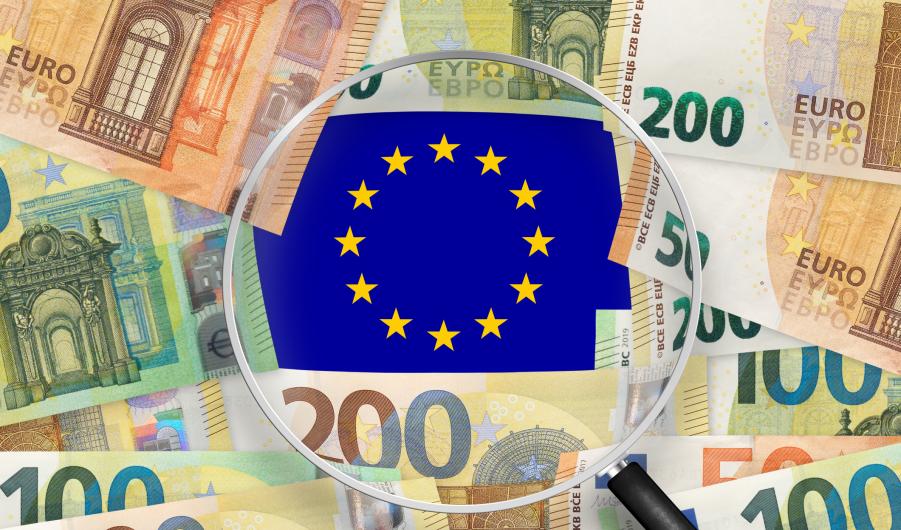 Euro notes with Europe Union flag view through magnifying glass
