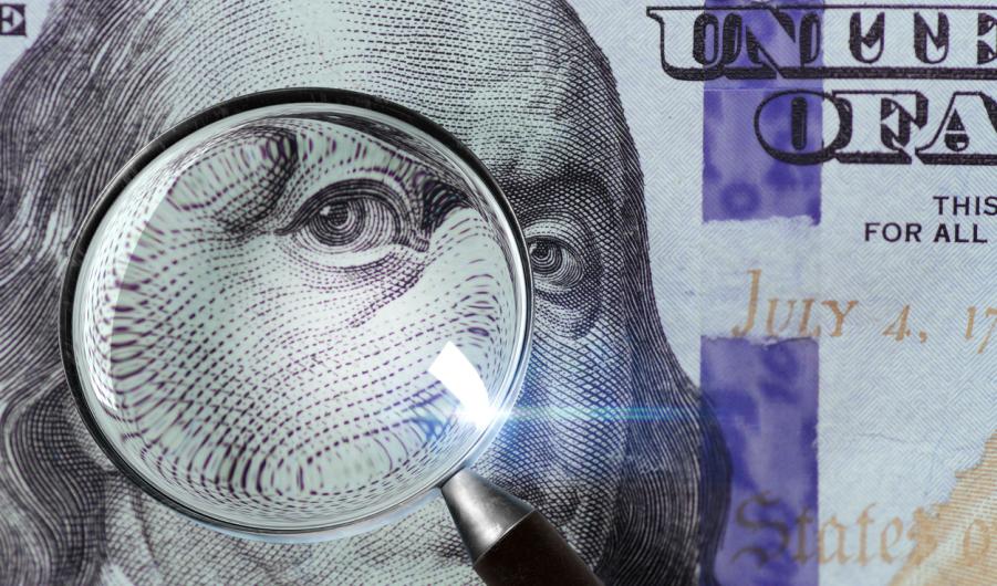 100 US Dollar under magnifying glass
