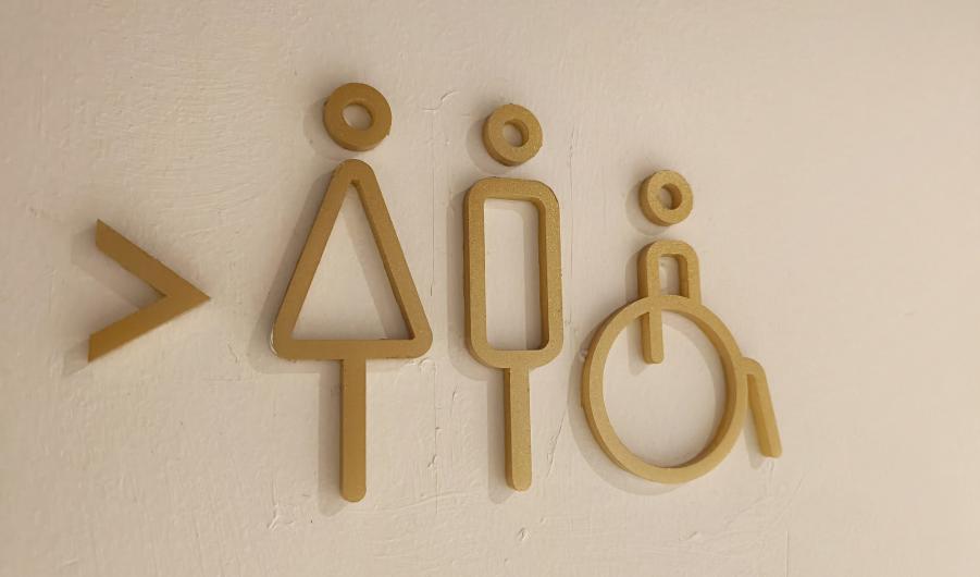 Toilet sign board hanging on wall.