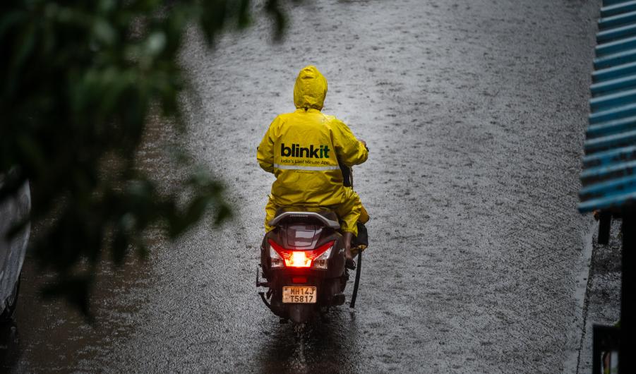 Blinkit gig driver on moped in the rain