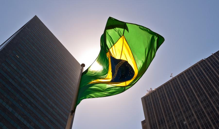 A Brazilian flag in front of skyscrapers