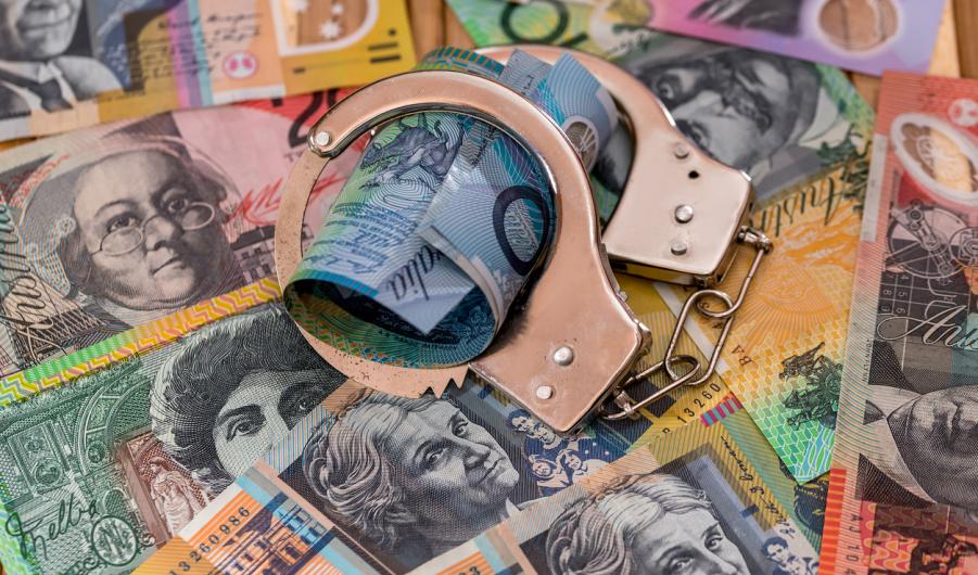 Steel handcuffs on australian dollars