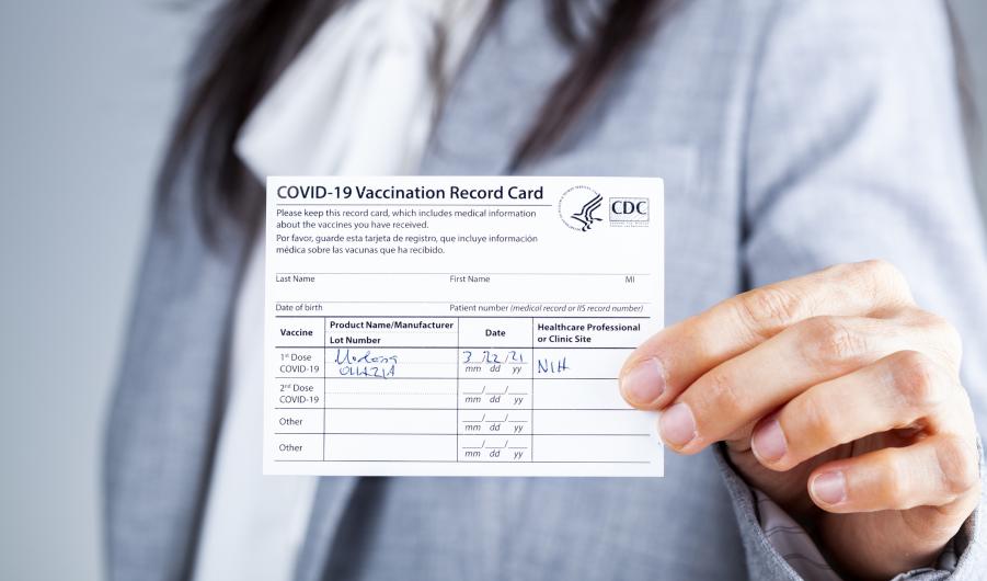 Woman showing Vaccination record card