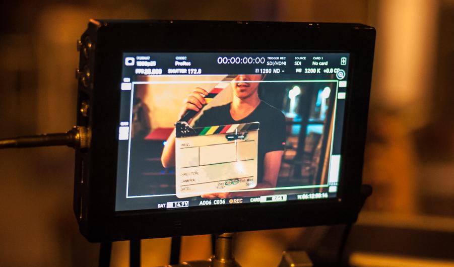 Man holding a clapper board in front of the camera 