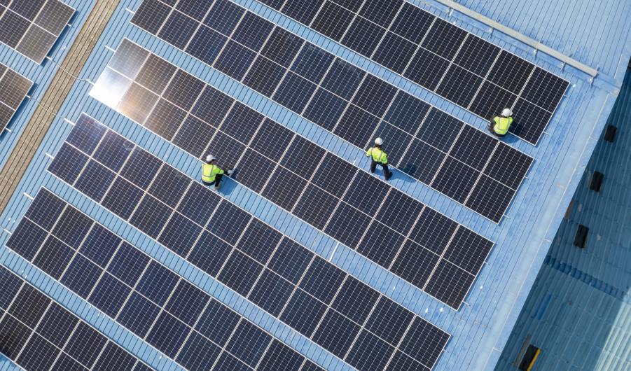 Engineers checking on solar panel on the factory rooftop 