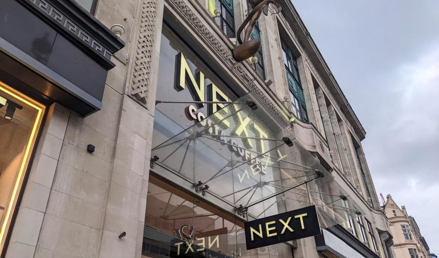 Next flagship store with Costa Coffee sign and bronze statue on Oxford Street in London