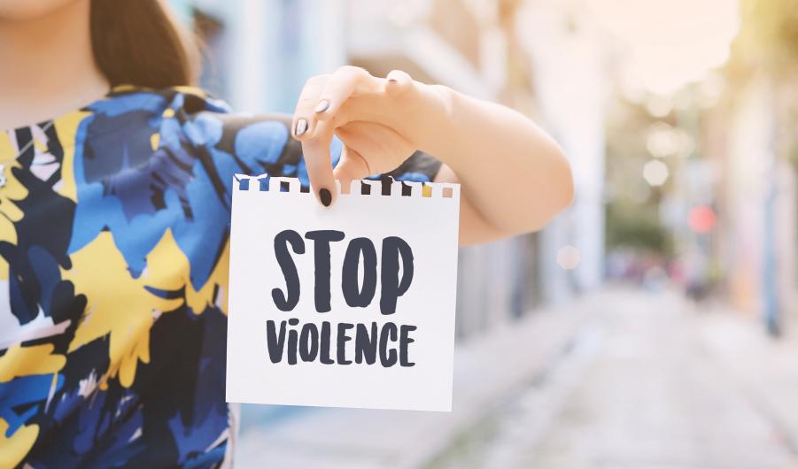 Young woman showing a notepad with the text "stop violence"